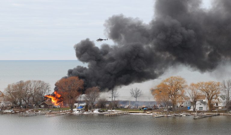   A house burns Monday, Dec. 24, 2012 in Webster, New York. An ex-con set a car and a house ablaze in his lakeside neighborhood to lure firefighters, then opened fire on them, killing two, engaging in a shootout with police and committing suicide while several homes burned. Authorities used an armored vehicle to evacuate the area. (AP Photo/Democrat & Chronicle, Jamie Germano)  