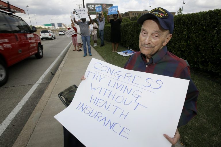 World War II veteran Jack Cooper, 93, of Richardson, Texas, holds a sign as he joins approximately 40 others demonstrating in front of the Social Security Administration building in Dallas on Oct. 2. (AP Photo/Tony Gutierrez)