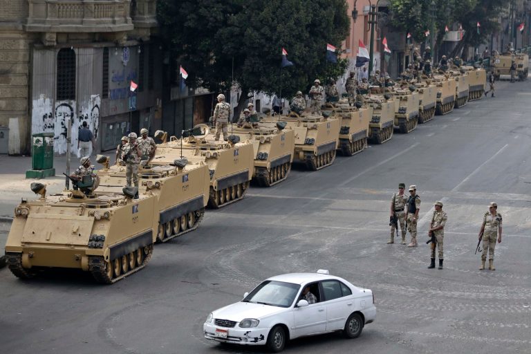 FILE - In this Friday, Aug. 16, 2013, file photo, Egyptian army soldiers take their positions on top and next to their armored vehicles to guard an entrance of Tahrir Square, in Cairo. U.S. officials said Wednesday, Oct. 9, 2013, that the Obama administration is poised to slash hundreds of millions of dollars in military and economic assistance to Egypt. (AP Photo/Hassan Ammar, File)