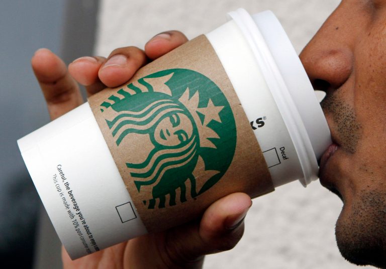 FILE - In this file photo taken July 26, 2011, a customer enjoys a coffee at Starbucks in Miami. It turns out Starbucks isn't contributing any upfront scholarship money to an online college degree program it introduced on Monday, June 16, 2014. (AP Photo/Alan Diaz, File)