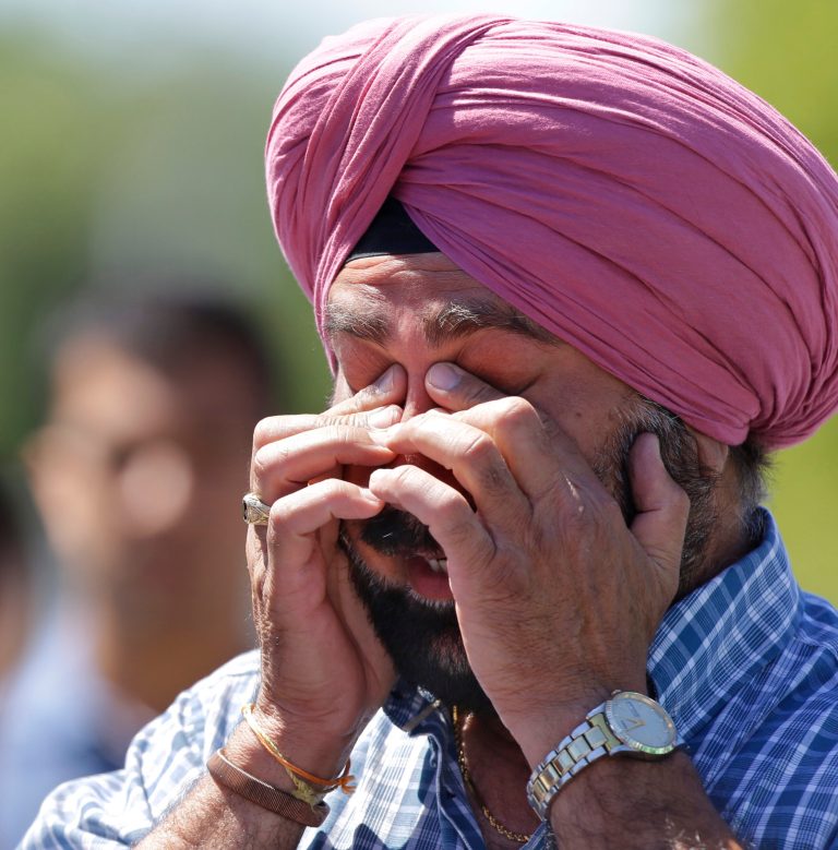 A man reacts outside the Sikh Temple of Wisconsin in Oak Creek, Wis. where a shooting took place on Sunday, Aug. 5, 2012. (AP Photo/Jeffrey Phelps)