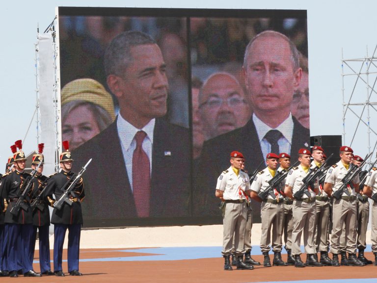 A large screen shows a picture of  Russian President Vladimir Putin, right, and U.S. President Barack Obama during the commemoration of the 70th anniversary of the D-Day in Ouistreham, western France, Friday, June 6, 2014. World leaders and veterans gathered by the beaches of Normandy on Friday to mark the 70th anniversary of World War Two's D-Day landings. (AP Photo/Christophe Ena, Pool)