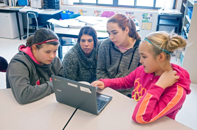 Maggie Paxton, left, Elizabeth Geelen, second from right, and Destiny Hampton, right, work with their teacher, Carrie Young, on a problem during a practice session for the Common Core State Standards Test. (AP Photo)Â 