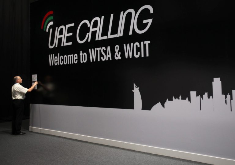   An official sticks a note on the wall next to the conference banner during the eleventh day of the World Conference on International Telecommunication in Dubai, United Arab Emirates, Monday Dec. 3, 2012. The head of the U.N.'s telecommunication overseers sought Monday to quell worries about possible moves toward greater Internet controls during global talks in Dubai, but any attempts for increased Web regulations are likely to face stiff opposition from groups led by a major U.S. delegation. (AP Photo/Kamran Jebreili)  