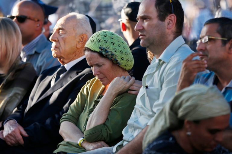 Rachel and Avi Fraenkel, parents of U.S.-Israeli national Naftali, 16, one of the three Israeli teens who were abducted and killed in the West Bank, mourn as they sit next to Israeli President Shimon Peres during their son'ss joint  funeral in the Israeli city of Modiin, Tuesday, July 1, 2014. Tens of thousands of mourners converged Tuesday in central Israel for the funeral service for three teenagers found dead in the West Bank after a two week search and crackdown on the Hamas militant group, which Israeli leaders have accused of abducting and killing the young men. The deaths of Eyal Yifrah, 19, Gilad Shaar, 16, and Naftali Fraenkel, a 16-year-old with dual Israeli-American citizenship, have prompted angry calls for revenge and Prime Minister Benjamin Netanyahu convened his security Cabinet for an emergency meeting to discuss a response to the killings, hours after airstrikes targeted dozens of suspected Hamas positions in the Gaza Strip.(AP Photo/Baz Ratner, Pool)