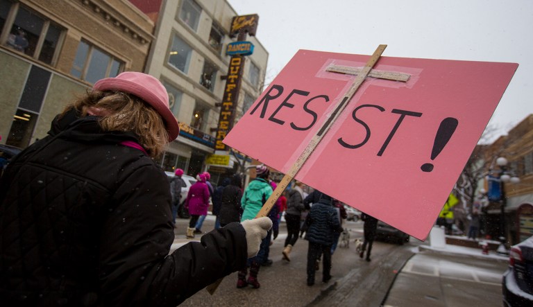 A woman carries a sign reading 