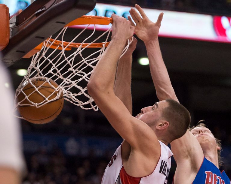   Toronto Raptors center Jonas Valanciunas, left, slams home a dunk past Detroit Pistons forward Kyle Singler, right, during first-half NBA basketball game action in Toronto, Wednesday, Dec. 19, 2012. (AP photo/The Canadian Press, Frank Gunn)  