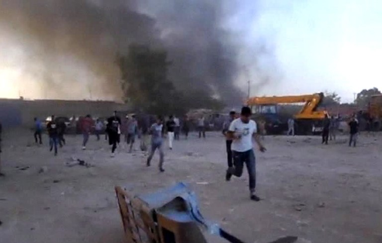 In this June 8, 2013 image made from video provided by Associated Press Television, Libyans run for cover after fighting broke out outside the office of Libya Shield pro-government militia in Benghazi, Libya. The violence which left dozens of people dead broke out Saturday when protesters stormed a base belonging to Libya Shield, a grouping of pro-government militias tasked with maintaining security. The protesters were demanding militias leave their camp and submit to the full authority of Libya's security forces. (AP Photo/APTV)  ** TV OUT **
