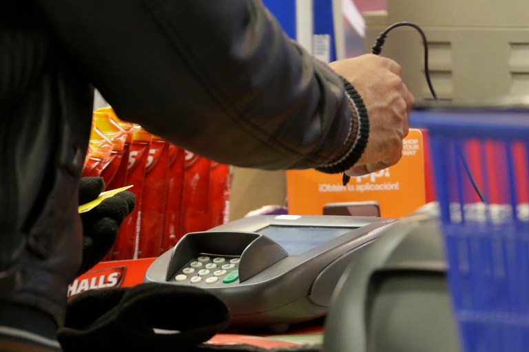 FILE - In this  Thursday, Nov. 28, 2013 file photo, a man pays with a credit card while shopping at KMart, in New York. The Federal Reserve reports on consumer borrowing for July 2014 on Monday, Sept. 8, 2014. (AP Photo/Julio Cortez, File)