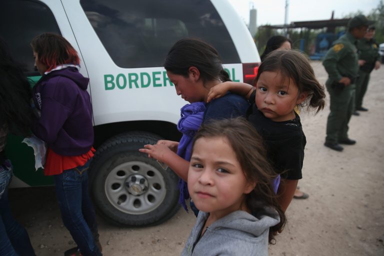 Central American immigrants await transportation to a U.S. Border Patrol processing center after crossing the Rio Grande from Mexico into the Texas on July 24, 2014 near Mission, Texas. (Photo by John Moore/Getty images)