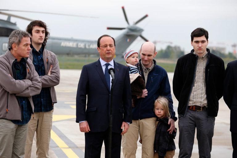 French President Francois Hollande, third from left, speaks with released French hostages, from left, Didier Francois, Edouard Elias, Nicolas Henin and Pierre Torres, at the Villacoublay military airbase, outside Paris, Sunday, April 20, 2014. The four French journalists kidnapped and held for 10 months in Syria returned home on Sunday to joyful families awaiting them. The four were freed by their captives a day earlier at the Turkish border. (AP Photo/Jacques Brinon)