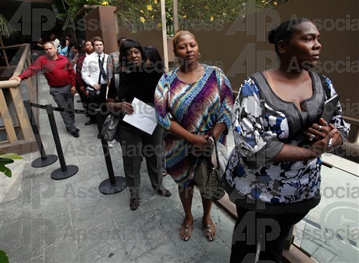 FILE - In this Friday, Aug. 17 2012, file photo, Sheila Bird, right, waits in line for employment interviews at a job fair at City Target in Los Angeles. (AP Photo/Nick Ut)