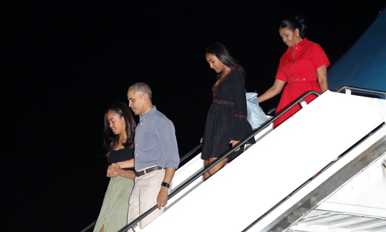 President Obama and first lady Michelle Obama, with their daughters Malia, left, and Sasha, second right, arrive on Air Force One at Joint Base Pearl Harbor-Hickam, adjacent to Honolulu, Hawaii, for their annual family vacation on the island of Oahu. (AP Photo/Carolyn Kaster)