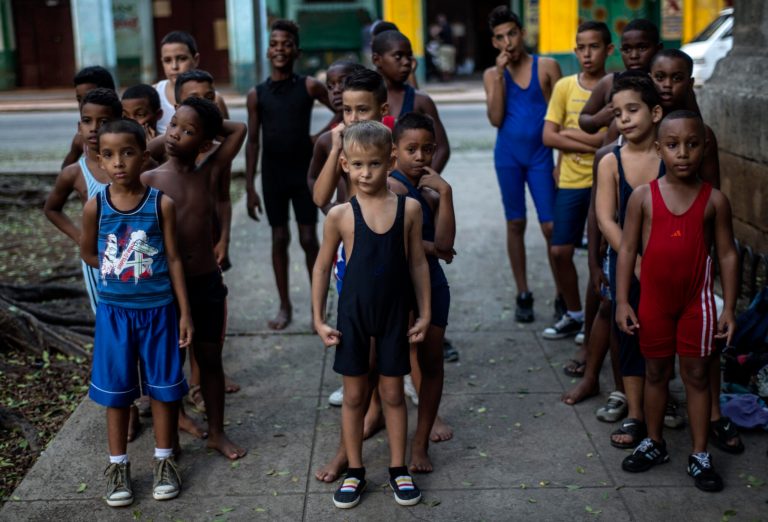 In this Oct. 13, 2014 photo, young wrestlers form lines at the start of their practice in a park in Old Havana, Cuba. The children are candidates to enter the Sports Initiation School, the first stage of sports training in Cuba, and specialize in wrestling. (AP Photo/Ramon Espinosa)