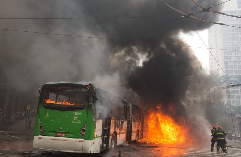 Firefighters work to douse the flames of a bus set on fire by housing activists during an eviction in downtown Sao Paulo, Brazil, Tuesday, Sept. 16, 2014. Police and members of the so-called 