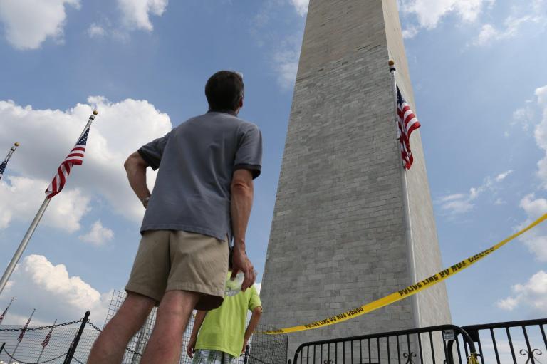 A man stares up at the earthquake-damaged Washington Monument, which will remain closed for repairs. Disappointed tourists will have to wait until 2014 to go to the top. (Graeme Jennings/Examiner)
