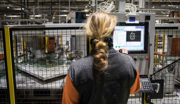 A worker operates a touchscreen computer at a robotic production line at the Fuyao Glass America plant, Friday, Oct. 7, 2016, in Moraine, Ohio. (AP Photo/John Minchillo)