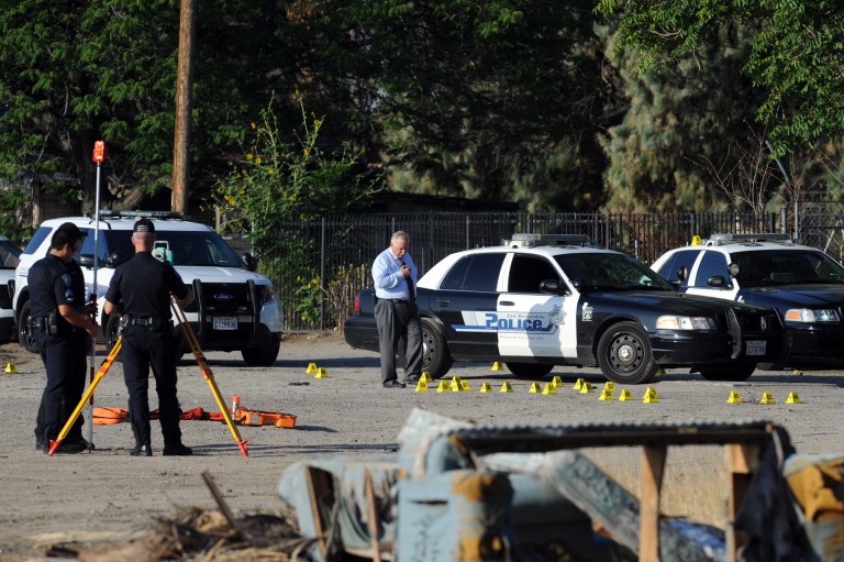 San Bernardino Police investigate the scene where a police officer shot and killed a gunman during an early morning shootout that began after another officer was gravely wounded, Friday, Aug. 22, 2014, in San Bernardino, Calif. (AP Photo/The Sun, Micah Escamilla) MANDATORY CREDIT