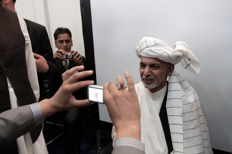 FILE - In this Sunday, Oct. 6, 2013 file photo, former Afghan Finance Minister Ashraf Ghani, right, is photographed by an official of the Independent Election Commission, as he registers his candidacy in the 2014 presidential election in Kabul, Afghanistan. Ghani is a former finance minister who ran in the 2009 presidential elections but received just 3 percent of the vote. A well-known academic with a reputation as a somewhat temperamental technocrat, Ghani chairs a commission in charge of transitioning responsibility for security from the U.S.-led coalition to Afghan forces. (AP Photo/Rahmat Gul, File)