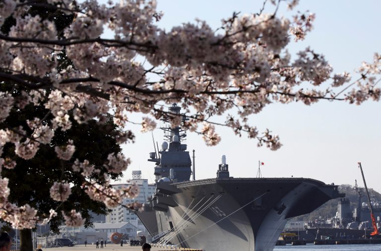 The latest destroyer Izumo of Japan's Maritime Self-Defense Force (JMSDF) is seen trough the cherry blossoms in Yokosuka, south of Tokyo, Tuesday, March 31, 2015. (AP Photo)
