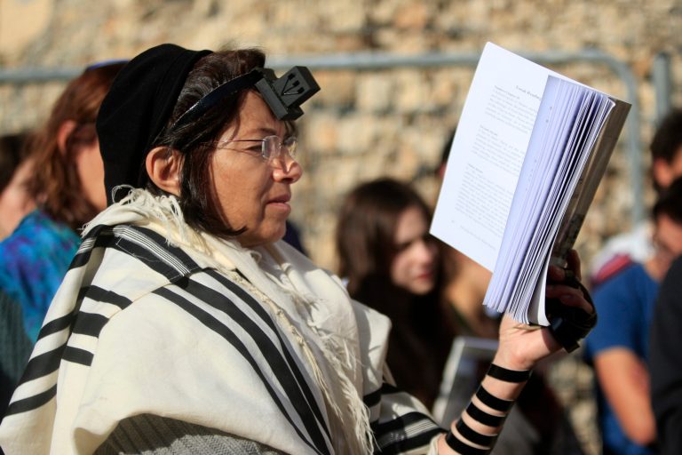   Israeli women of the Women of the Wall organization pray just outside the Western Wall, the holiest site where Jews can pray in Jerusalem's old city, Friday, Dec. 14, 2012. Security guards at the Western Wall, the holiest place where Jews can pray, usually search worshippers for weapons upon entering. But on Friday, they were on the lookout for a seemingly inoffensive possession: Jewish prayer shawls. The shawls are ubiquitous at the holy site, and under Orthodox tradition, are worn only by men. When several dozen women draped in them attempted to enter the area, their multicolored garments were confiscated. (AP Photo/Dan Balilty)  