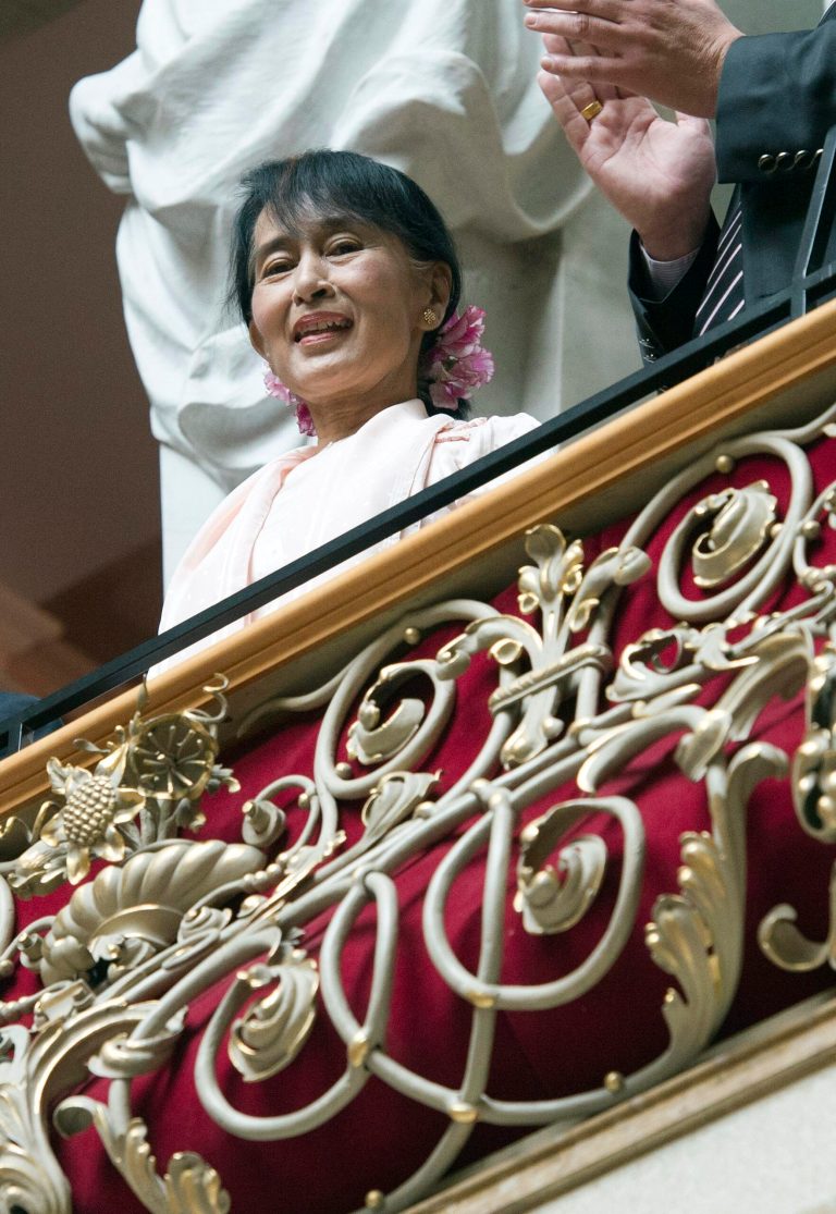   Myanmar opposition leader Aung San Suu Kyi sits on the balcony during her visit to the government building in Bern, Switzerland, Friday, June 15, 2012. The European trip is seen as a sign of gratitude to governments and organizations that supported Suu Kyi's peaceful struggle against Myanmar's former military rulers over more than two decades, 15 years of which she spent under house arrest. (AP Photo/Lukas Lehmann)  