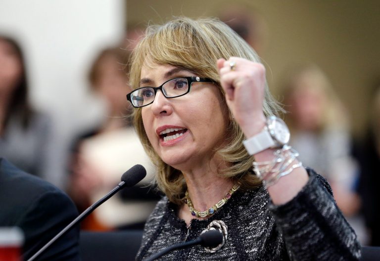 Former Arizona Congresswoman Gabrielle Giffords pumps her fist as she testifies before a Washington state House panel Tuesday, Jan. 28, 2014, in Olympia, Wash. Giffords, who survived a 2011 shooting, testified before the panel considering an initiative to expand firearm background checks in the state, telling lawmakers that 