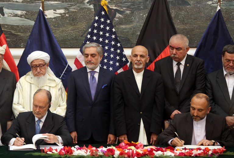 Afghanistan's national security adviser Mohmmad Hanif Atmar, seated at right, and U.S. Ambassador James Cunningham, left, sign the documents of the Bilateral Security Agreement (BSA) at presidential palace as Afghanistan's president Ashraf Ghani Ahmadzai, center right, and chief executive Abdullah Abdullah, center left, watch, in Kabul, Afghanistan, Tuesday, Sept. 30, 2014. Afghanistan and the United States signed a long-awaited security pact on Tuesday that will allow U.S. forces to remain in the country past the end of year. (AP Photo/Massoud Hossaini)