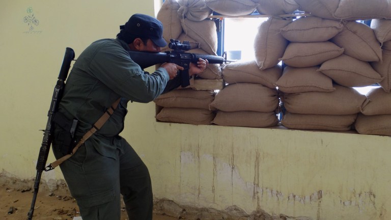 An Iraqi Sunni tribal fighter aims his gun to protect the headquarters from an attack by Islamic State extremists during a sand storm in the eastern part of Ramadi, Thursday, May 14, 2015. (AP Photo)Â 