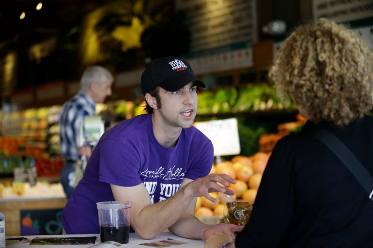 Andrew Pittz of the Sawmill Hollow aronia berry farm offers samples and sells aronia berry products at Whole Foods Market in Omaha, Neb., Friday, April 25, 2014.  A few years ago, few people had ever heard of the Aronia berry, a pretty, but tart fruit. Now, the berry has set its sights on becoming the next 