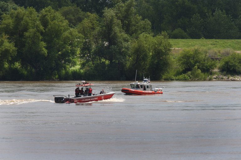 In this Tuesday, July 1, 2014 photo, a St. Louis Fire Department boat and a U.S. Coast Guard are seen searching for a sunken towboat in the Mississippi River near the Stan Musial Veterans Memorial Bridge in St. Louis. The Coast Guard says the 70-foot, 140-ton Jim Marko went under Tuesday. Four crew members were rescued. Authorities have reopened the Mississippi River at St. Louis to barge traffic as salvage crews sort out how to remove a towboat that sank with possibly 10,000 gallons of diesel fuel aboard. (AP Photo/The St. Louis Post-Dispatch, Cristina Fletes-Boutte) EDWARDSVILLE INTELLIGENCER OUT; THE ALTON TELEGRAPH OUT