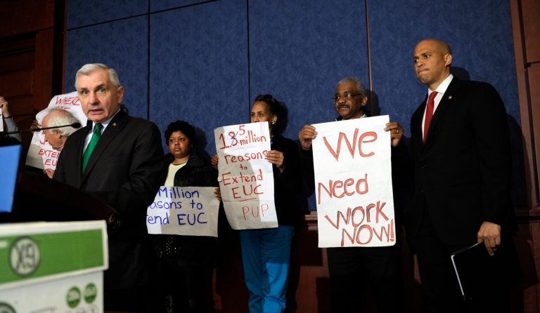 Sen Cory Booker, D-N.J.  listens at right as Sen. Jack Reed, D-R.I., speaks about unemployment benefits during a news conference on Capitol Hill in Washington. The number of Americans seeking unemployment benefits fell 2,000 last week to a seasonally adjusted 326,000, a sign that layoffs are weighing less on the job market and economic growth. (AP/Susan Walsh)