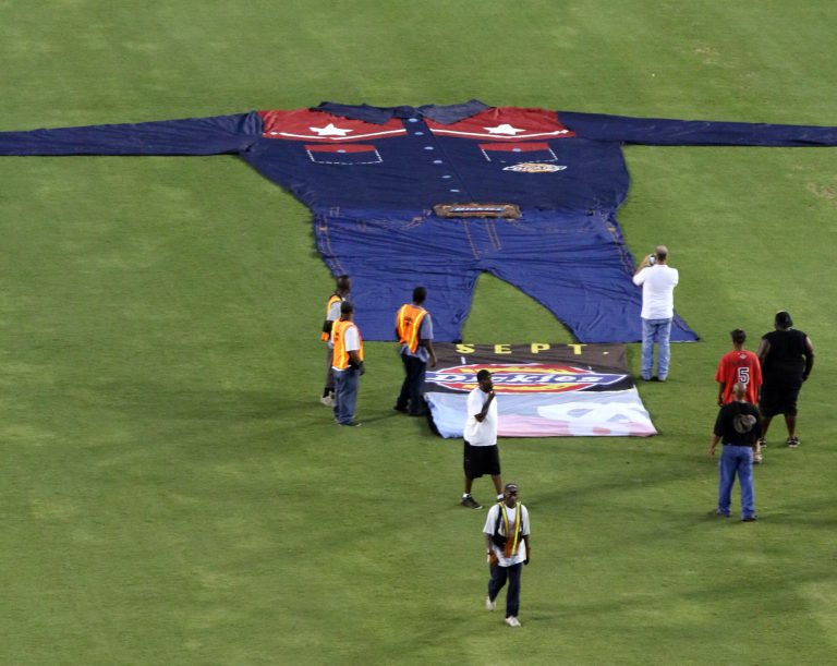 State Fair of Texas workers adjust the new clothes of Big Tex on the floor of the Cotton Bowl Stadium in Dallas, Tuesday, Aug. 26, 2014. Big Tex is getting some new duds that he'll wear to greet some 3 million people who are expected to attend the State Fair of Texas beginning next month.  (AP Photo/State Fair of Texas)