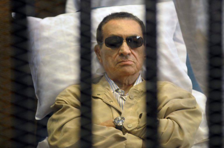 In this June 2 file photo, Egypt's ex-President Hosni Mubarak lays on a gurney inside a barred cage in the police academy courthouse in Cairo, Egypt. (AP Photo)