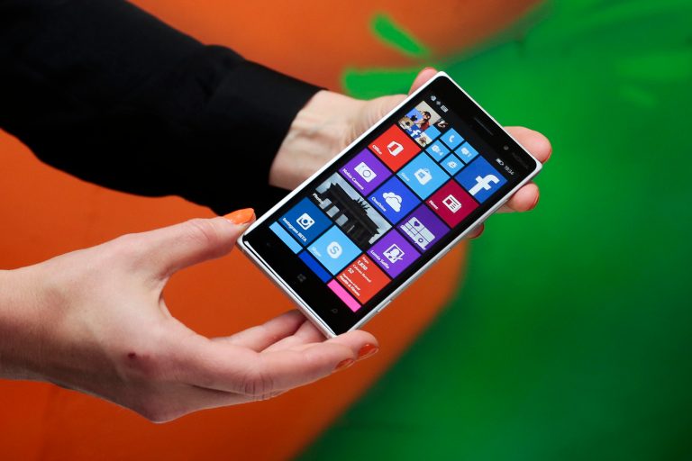 A woman shows the new Lumia 830 smart phone during a Microsoft Nokia presentation event at the consumer electronic fair IFA in Berlin, Thursday, Sept. 4, 2014. (AP Photo/Markus Schreiber)