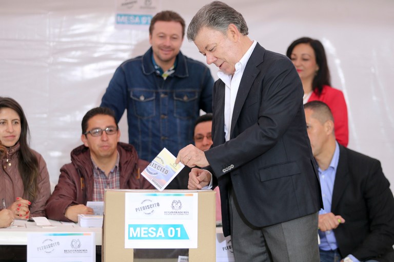 Colombia's President Juan Manuel Santos votes in a referendum to decide whether or not to support the peace deal he signed with rebels of the Revolutionary Armed Forces of Colombia, FARC, in Bogota, Colombia. (AP Photo/Fernando Vergara)