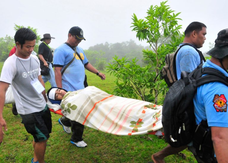 Police and rescuers carry Nicas Mabao Jr. to a waiting ambulance after surviving a steam-driven explosion of Mayon volcano, one of the Philippines' most active volcanoes, Tuesday May 7, 2013 in Albay province about 450 kilometers (285 Miles)southeast of Manila, Philippines. Mayon volcano rumbled to life Tuesday, spewing room-sized rocks toward nearly 30 surprised climbers, killing five and injuring others that had to be fetched with rescue helicopters and rope. (AP Photo/Nelson Salting)