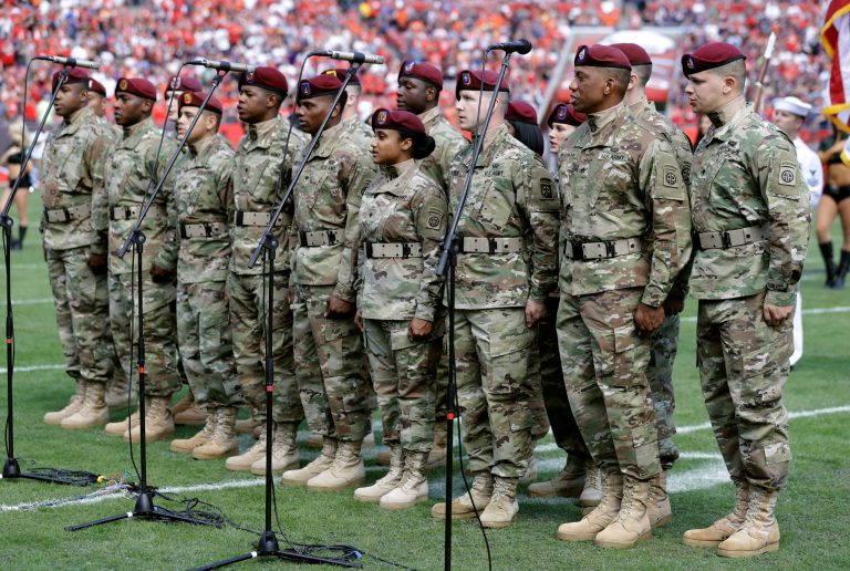 A U.S. Army group sings the National Anthem before an NFL football game last weekend. A new poll says most troops are excited about a Trump presidency, but a little more than a quarter of them are nervous. (AP Photo/Chris O'Meara)