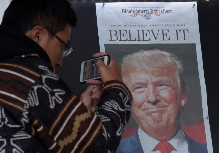 Zheng Gao of Shanghi, China, photographs the front pages of newspapers on display outside the Newseum in Washington the day after Donald Trump won the presidency. (AP Photo/Susan Walsh)
