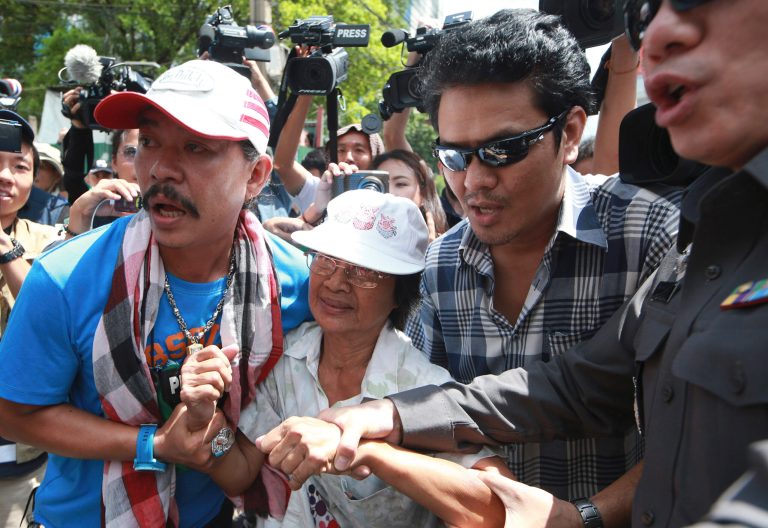 A protester, center, is arrested by plainclothes Thai police officers after staging an anti-coup demonstration in Bangkok, Thailand Sunday, June 1, 2014. An anti-coup activist in Thailand called Friday for a weekend rally to defy the military government's ban on demonstrations, urging those opposed to the takeover to wear masks and be ready for cat-and-mouse chases with soldiers in the capital. (AP Photo/Wason Wanichakorn)