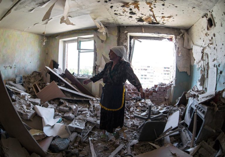 Valentina, who gave only her first name, gestures in a flat of her neighbor who was injured during shelling in the city of Kramatorsk, Donetsk region, eastern Ukraine, Thursday, July 3, 2014. Residential areas came under shelling on Thursday from government forces. (AP Photo/Dmitry Lovetsky)