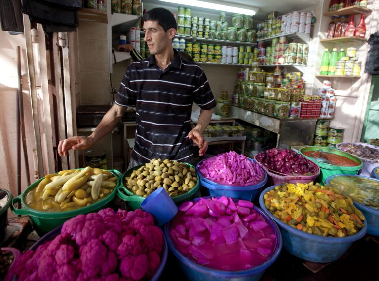 A Palestinian vendors displays food, including pickled vegetables and olives, in preparation for Ramadan at a market in the West Bank city of Hebron, Saturday, June 28, 2014. Muslims throughout the world are preparing themselves for the holy month of Ramadan, when the observant fast from dawn till dusk. (AP Photo/Majdi Mohammed)