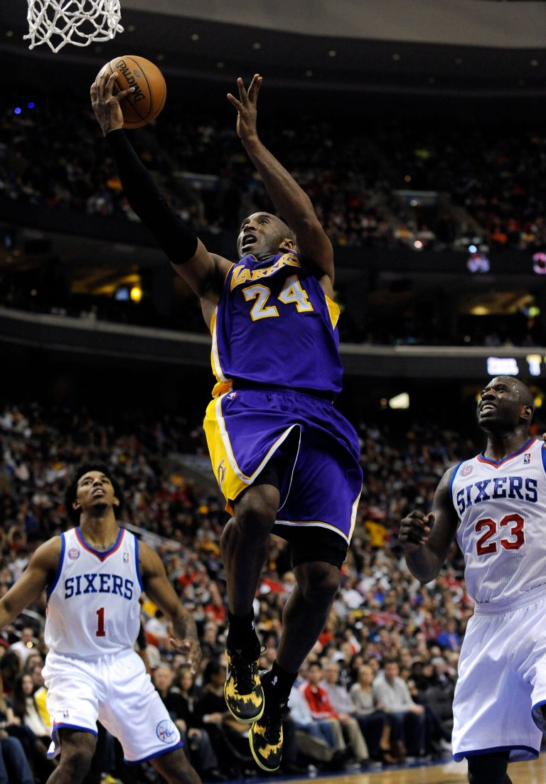   Los Angeles Lakers' Kobe Bryant (24) shoots over Philadelphia 76ers' Jason Richardson (23) and Nick Young (1) during the first half of an NBA basketball game on Sunday, Dec. 16, 2012, in Philadelphia. (AP Photo/Michael Perez)  