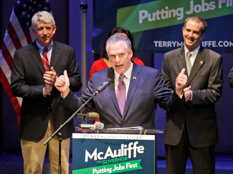 Democratic gubernatorial candidate, Terry McAuliffe, center, points to Lt. governor candidate, State Sen. Ralph Northam, right, and attorney general candidate, Sen. Mark Herring, left, during a breakfast appearance in Richmond, Va., Wednesday, June 12, 2013.  The trio will face Republican candidates in the November election.  (AP Photo/Steve Helber)