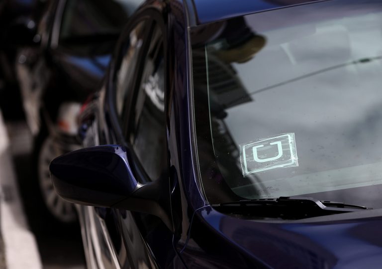 A sticker with the Uber logo is displayed in the window of a car. (Getty images/ Justin Sullivan)