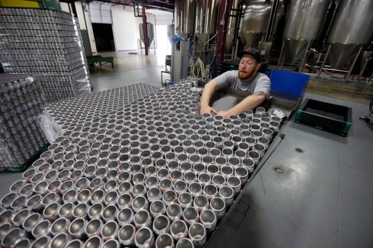 FILE - In this June 3, 2013 file photo, a worker loads empty cans onto the assembly line the Sly Fox Brewing Company in Pottstown, Pa. The Commerce Department reports, on Thursday, July 10, 2014, how much U.S. wholesale businesses adjusted stockpiles in May in response to their sales. (AP Photo/Matt Rourke, File)