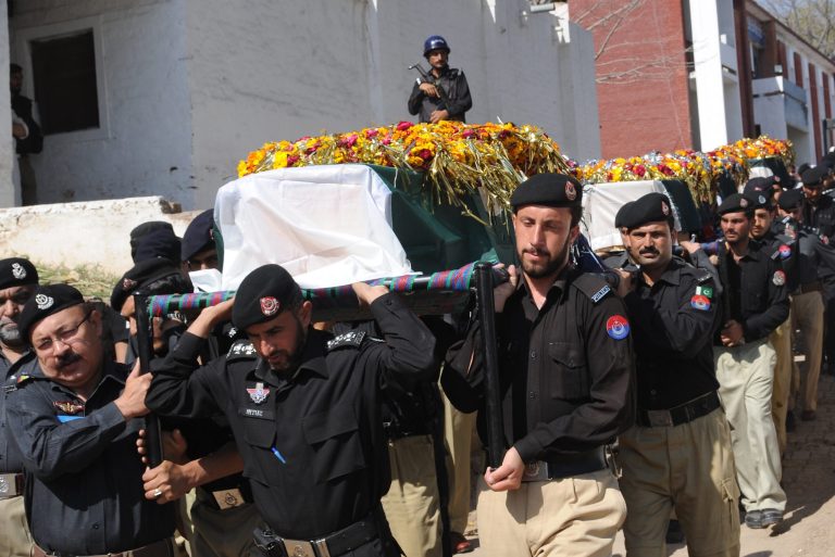 Pakistani police officers carry the coffins of their colleagues killed in an ambush on a police patrol,  in Peshawar, Pakistan, Tuesday, April 22, 2014. Two militant attacks in northwestern Pakistan killed many people, including five policemen, on Tuesday, officials said. There was no claim of responsibility for the attacks but provincial police chief Nasir Durrani said the attacks were retaliation for recent arrests of Taliban militants in the region. (AP Photo/Mohammad Sajjad)
