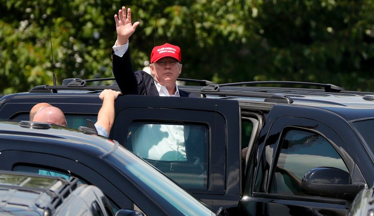 President Donald Trump waves to spectators as he climbs into a car outside his residence at the Trump National Golf Club during the third round of the U.S. Women's Open Golf tournament Saturday, July 15, 2017, in Bedminster, N.J. (AP Photo/Julie Jacobson)