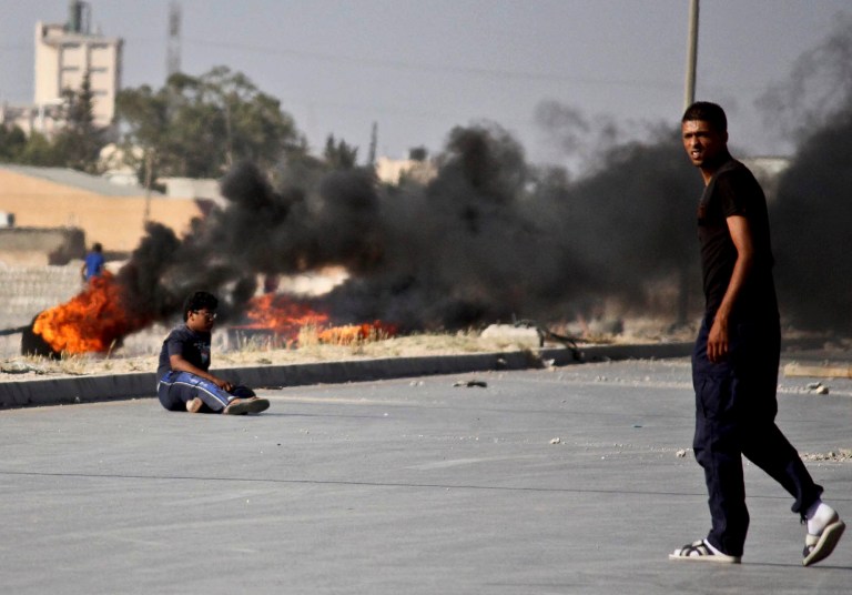 People fight outside the office of the Libya Shield pro-government militia in Benghazi, Libya, on June 8. (AP Photo)