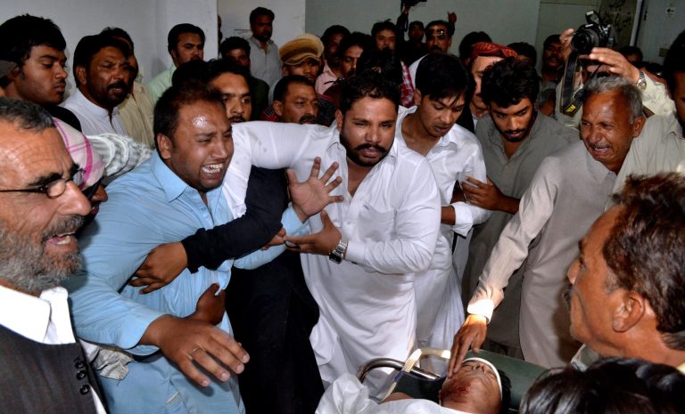 Pakistani men mourn over the lifeless body, bottom right, of a provincial lawmaker Handery Masieh at a local hospital in Quetta, Pakistan, Saturday, June 14, 2014. A guard for a provincial Christian lawmaker shot and killed the legislator during a meeting Saturday in southwest Pakistan, police said. Government spokesman Jan Mohammad Buledi said the guard fled after the attack and police were trying to arrest him. 
